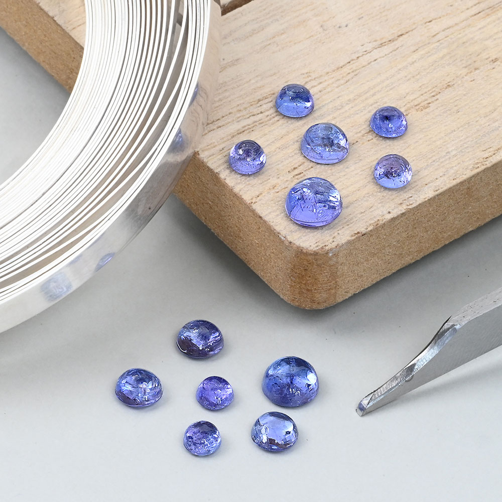 Tanzanite round cabochons with fine silver bezel wire to the left and a graver bottom right